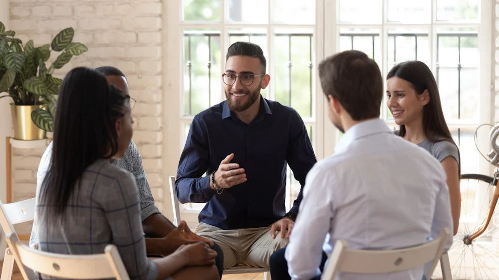 benefits-of-group-therapy-for-mental-health a group of people sitting in circle during therapy
