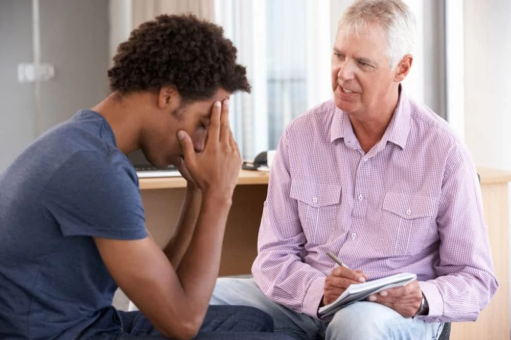 man suffering from anxiety is talking to a therapist