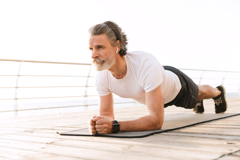 A man doing a plank exercise promoting physical wellness as part of mental health treatment