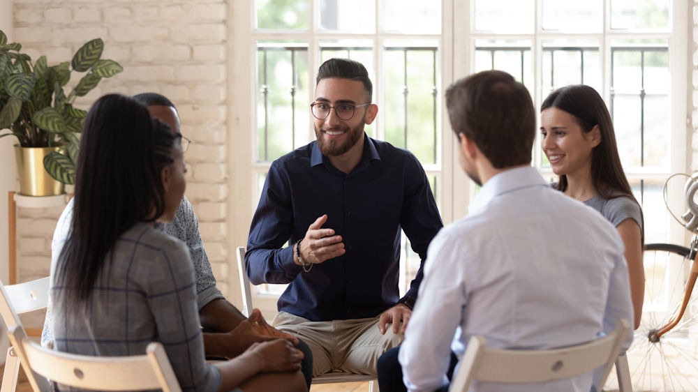 a group of people sitting in circle during therapy