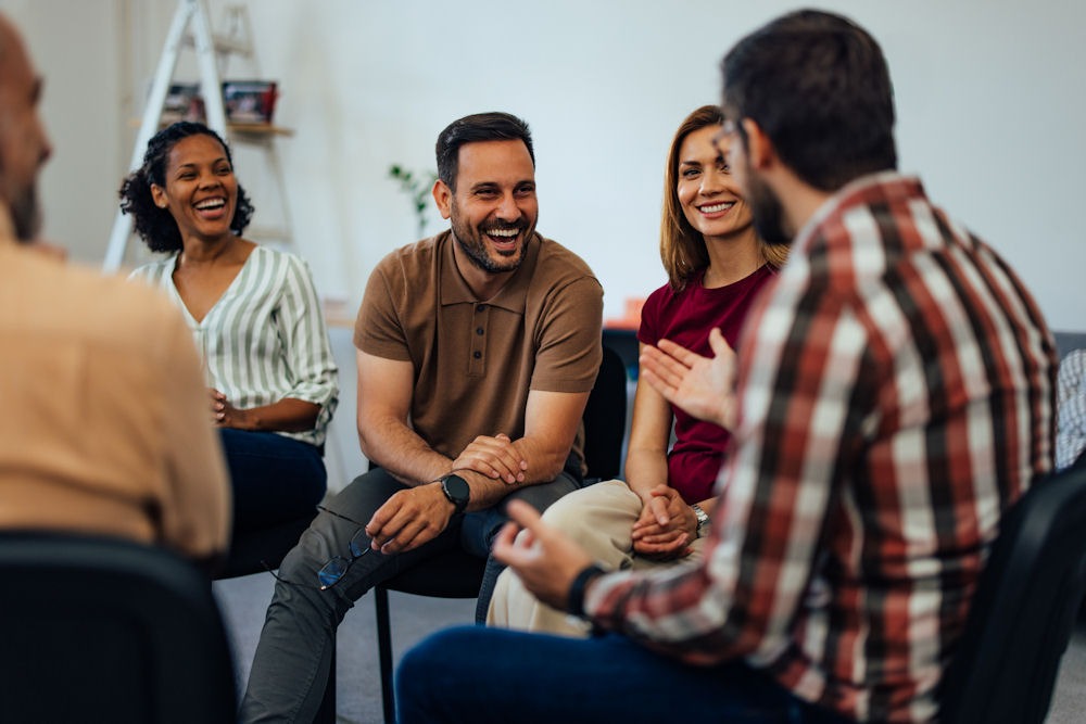a group of people laughing while having a discussion