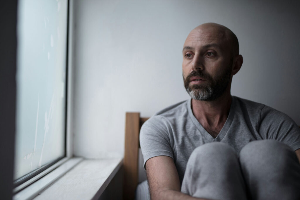 Man experiencing emotional exhaustion and isolation due to burnout and depression.
